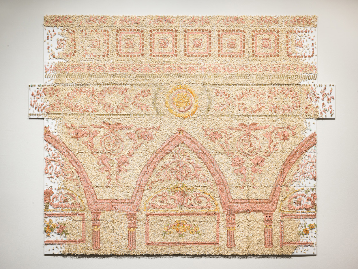 A large contemporary art installation of a decorative architectural cornice made of countless pink and yellow cut paper insects.