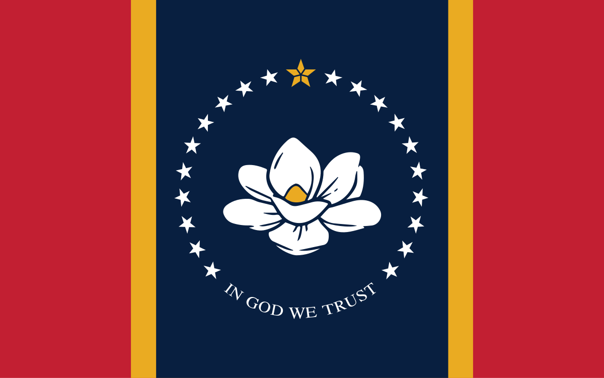 The new Mississippi flag, which features a white illustrated magnolia blossom with a yellow center in the middle of the flag. White starts surround the blossom in a circle, with "In God We Trust" written along the bottom. On either side of the flag is a thick red stripe, followed by a thin gold stripe (moving inwards). The center background is navy blue.