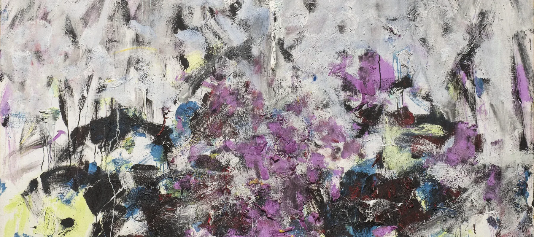 A vertical, abstraction features broadly painted strokes of pale gray, lavender, and cobalt in the upper two-thirds of the canvas. The colors continue in the lower third, along with touches of green, black, and other hues, but the expressive brushwork becomes denser and chaotic.