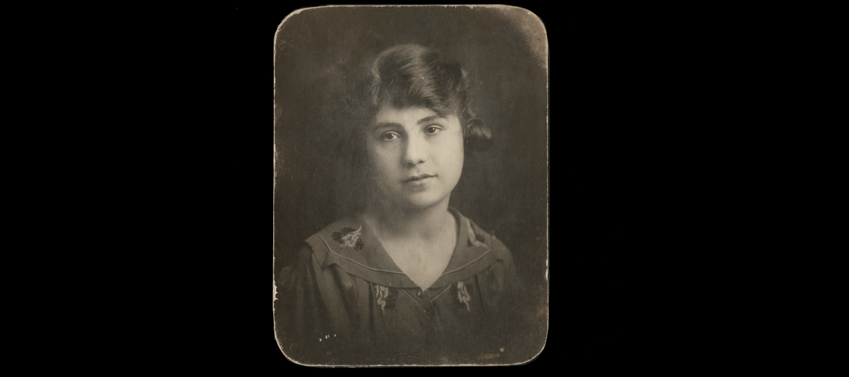 An antique sepia photo portrait of a light-skinned woman with brown hair staring longingly at the camera.