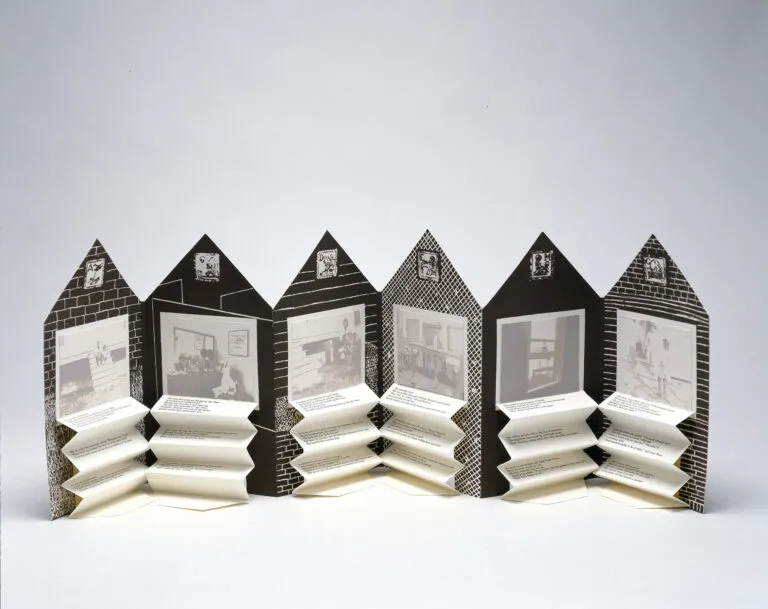 An open accordion-style book in the shape of a house. On each page is a black and white graphic background and a washed-out black and white photograph. Beneath each image is typed text on accordion folded paper.