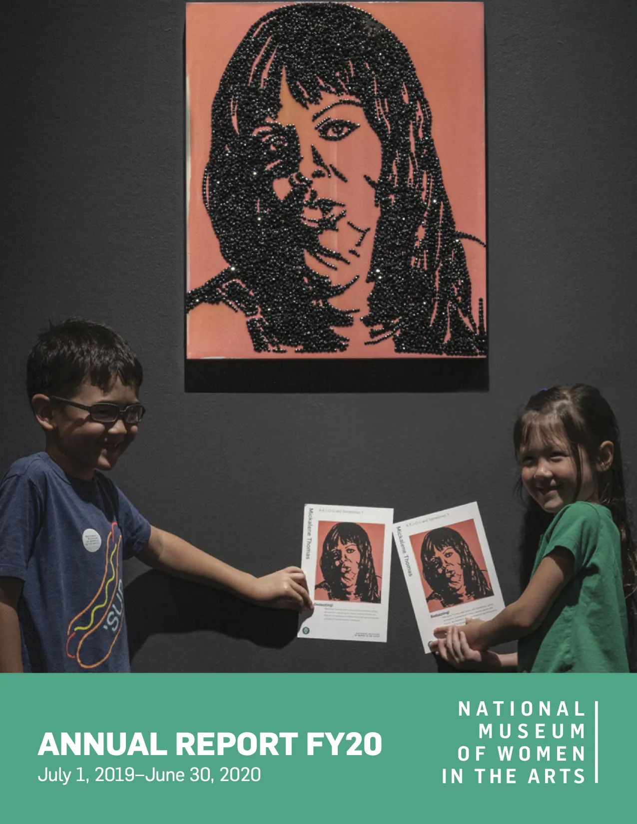 Annual report cover with an image of two children in the gallery holding up postcards with reproductions of the mixed media artwork hanging on the wall behind them.