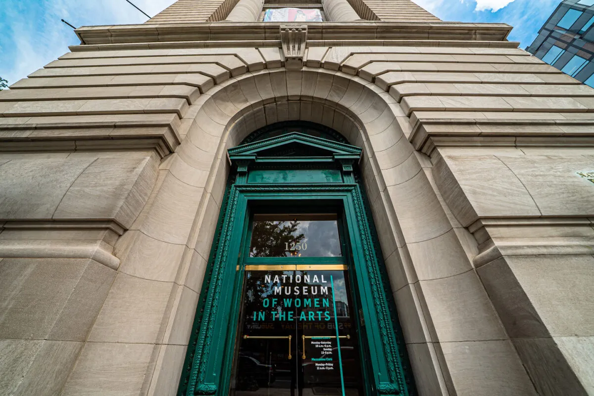 Front-facing photo of the museum's exterior shot from the ground looking up with a green door frame in the center.