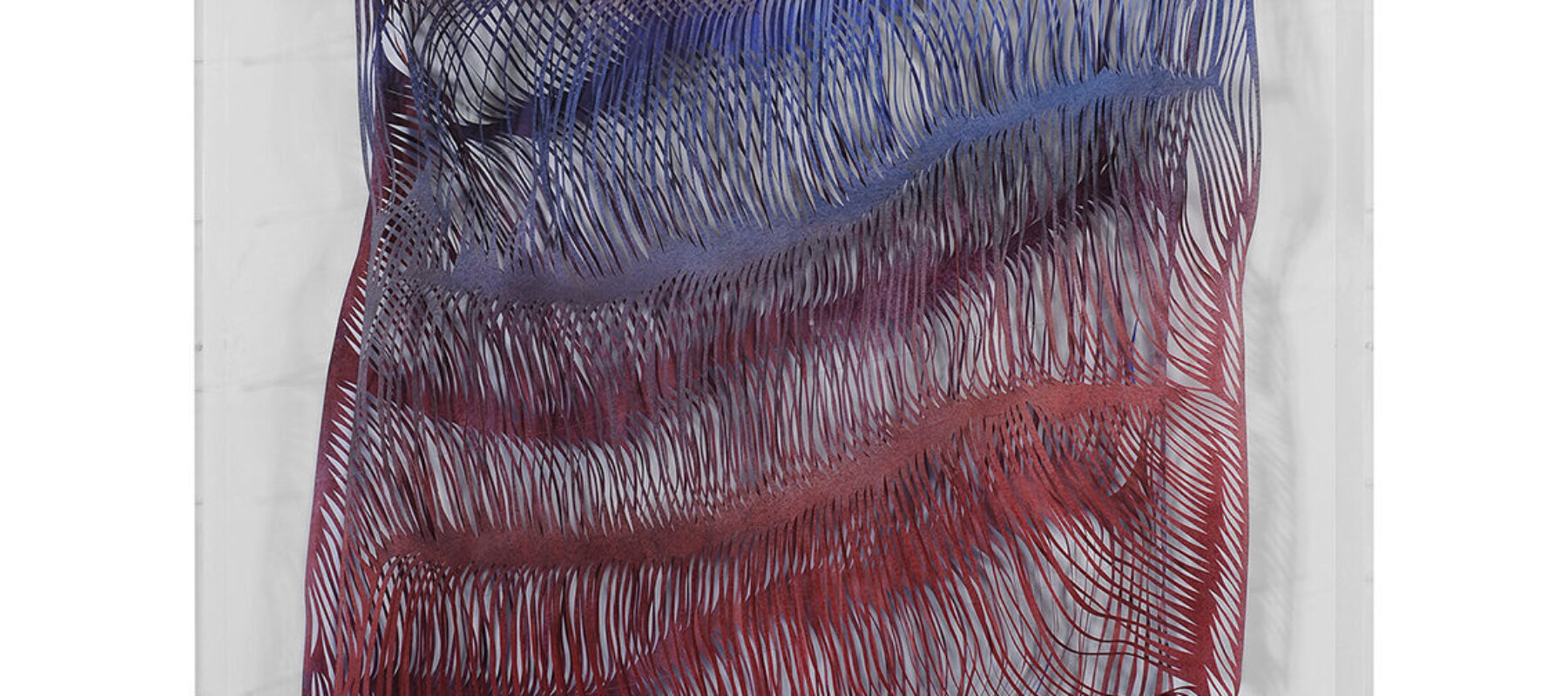 A rectangular paper work in a plexiglass box that shows thousands of slashes through the work to create waves and shadows throughout the surface. The color shifts from purple at the top to blue to red at the bottom.