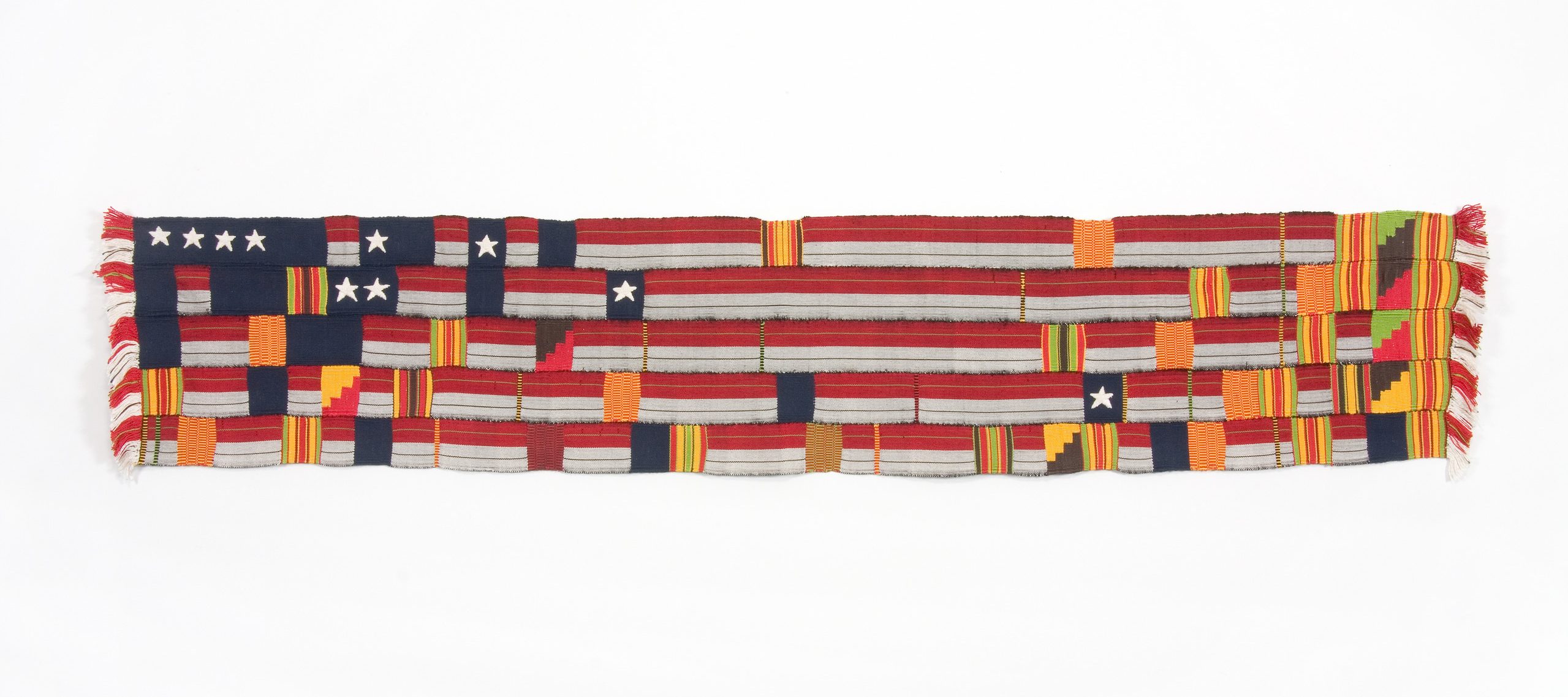 A horizontal, rectangular fabric artwork, made of woven strips of silk and cotton. The colors of the horizontal fabric strips are red, white, and blue, reminiscent of the American flag, while interwoven the vertical strips are shades of yellow, orange and green.