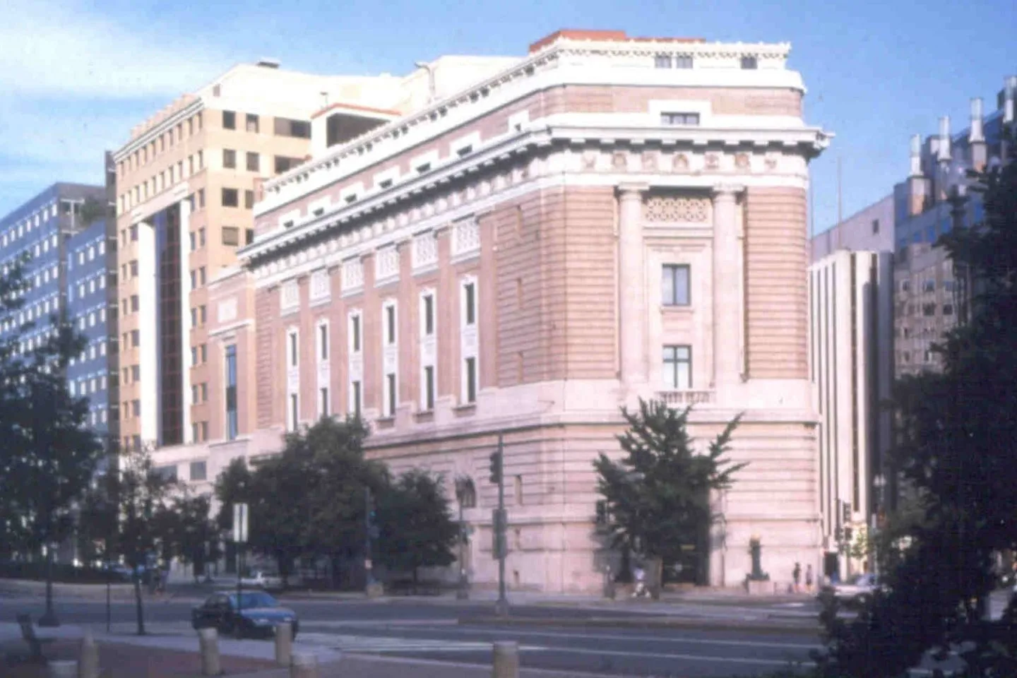 An older color photograph of the building exterior with trees in the foreground.