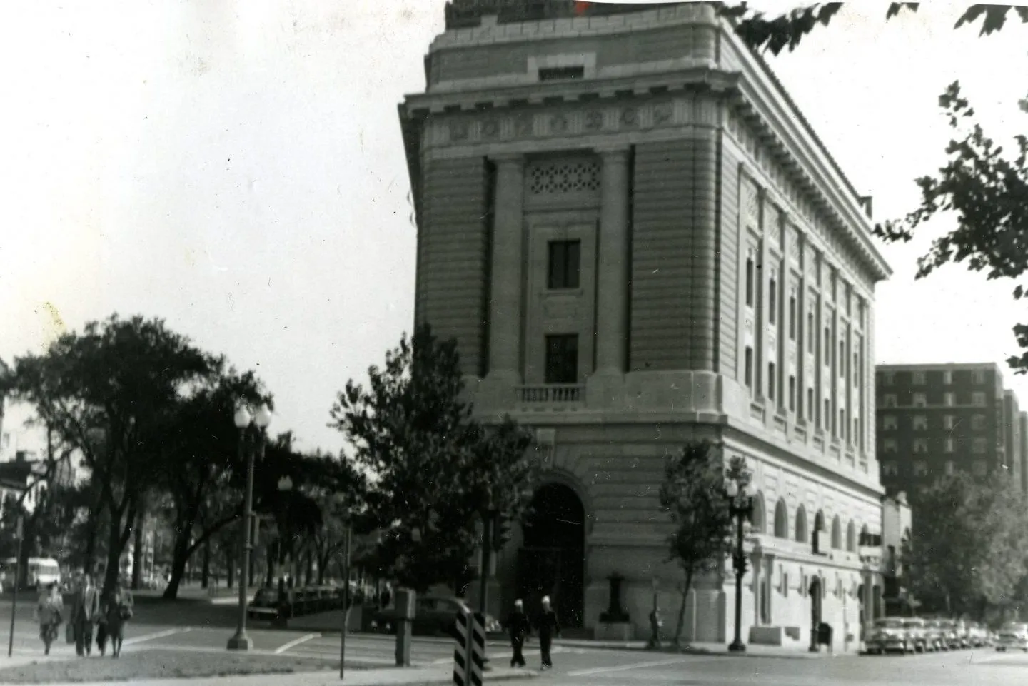 Black-and-white historic photograph of the building exterior with trees in the foreground.