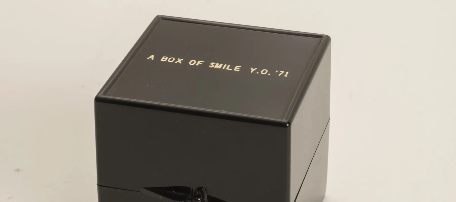 A small black square box that has "A Box Of Smile, Y.O. '71" printed on the lid.