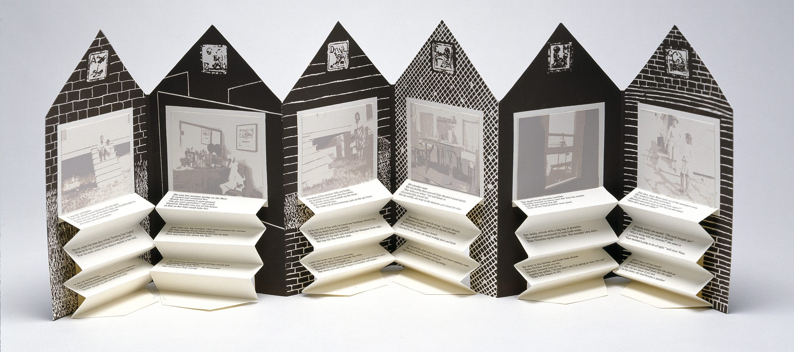 An open accordion-style book in the shape of a house. On each page is a black and white graphic background and a washed-out black and white photograph. Beneath each image is typed text on accordion folded paper.