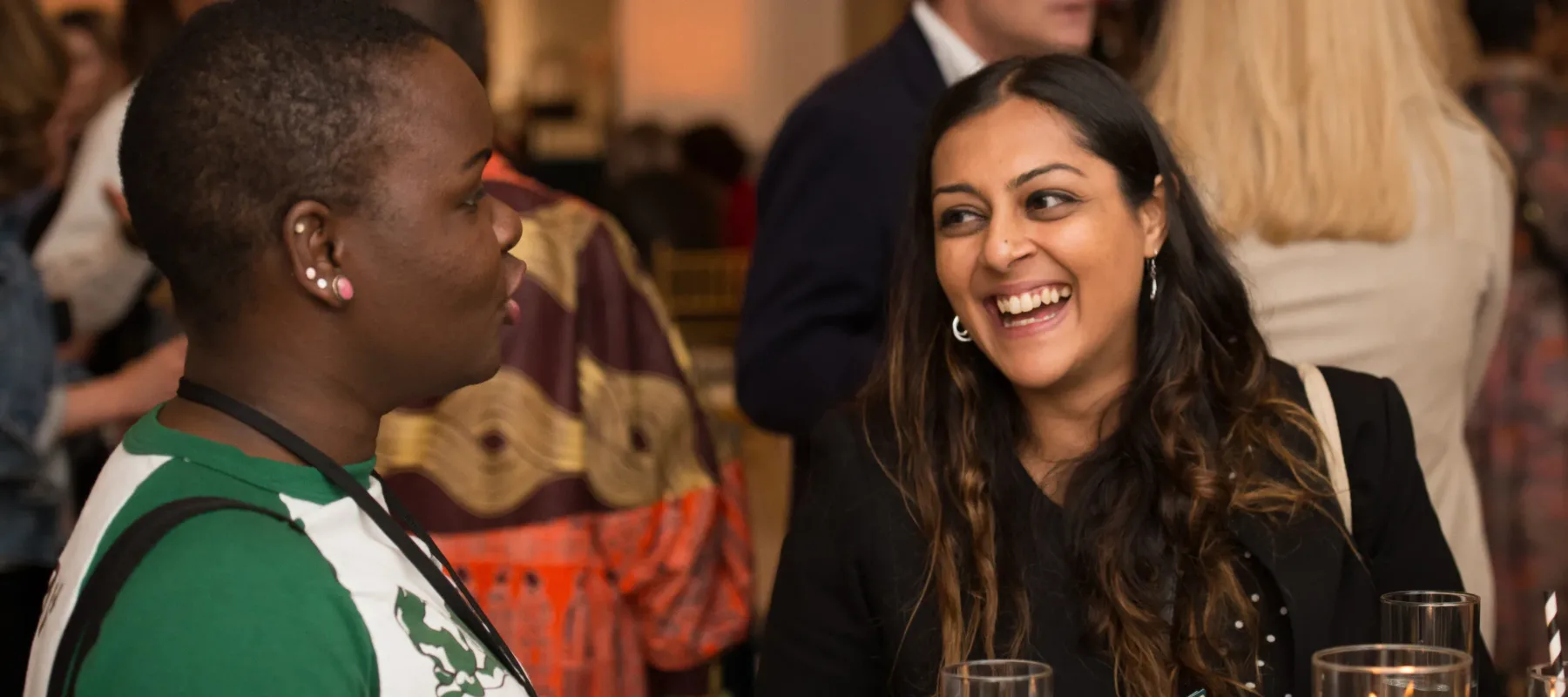 Two women engage in discussion at a table.