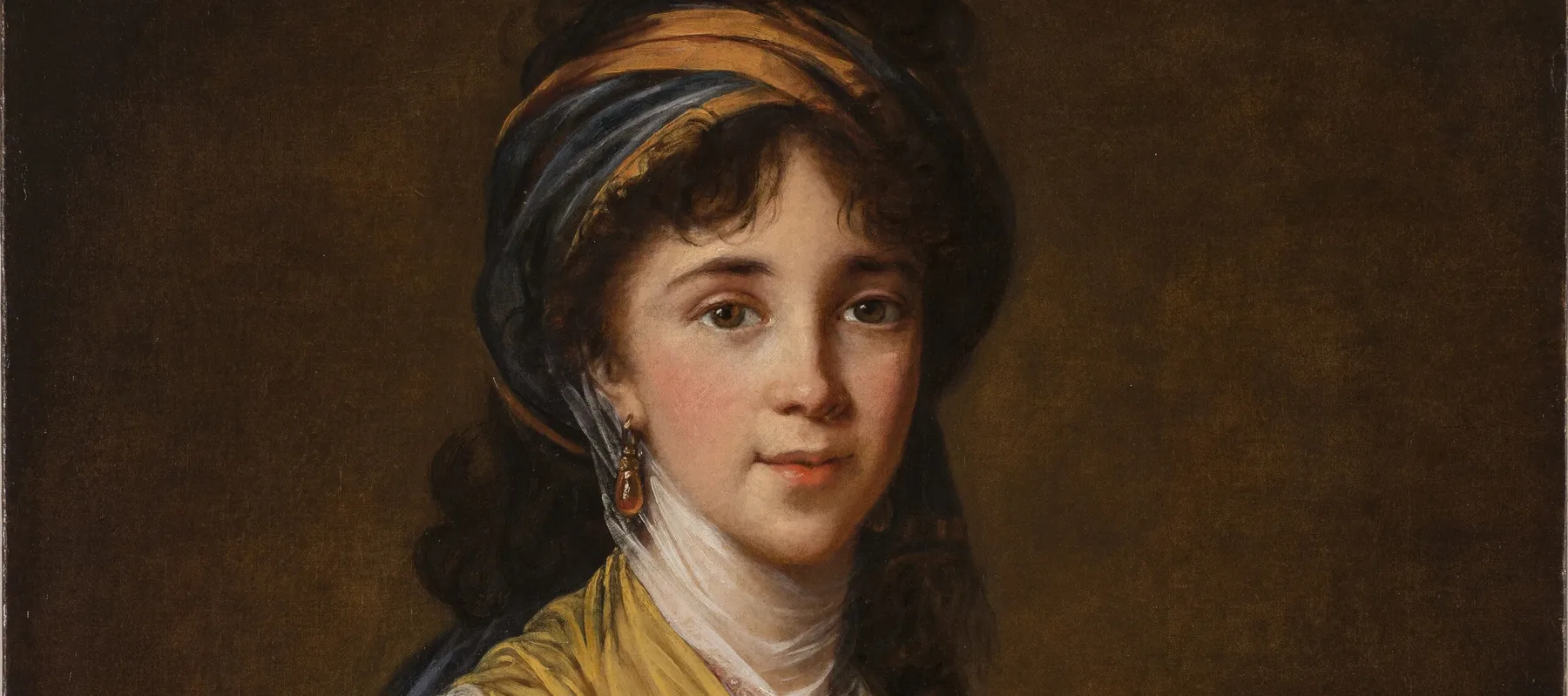 Realistically rendered half-portrait of a light-skinned young woman, gazing directly at the viewer with a faint smile on her lips. Her dark, curly hair is attractively tousled, secured under a turban-like headdress which matches her gold and blue draped ensemble.