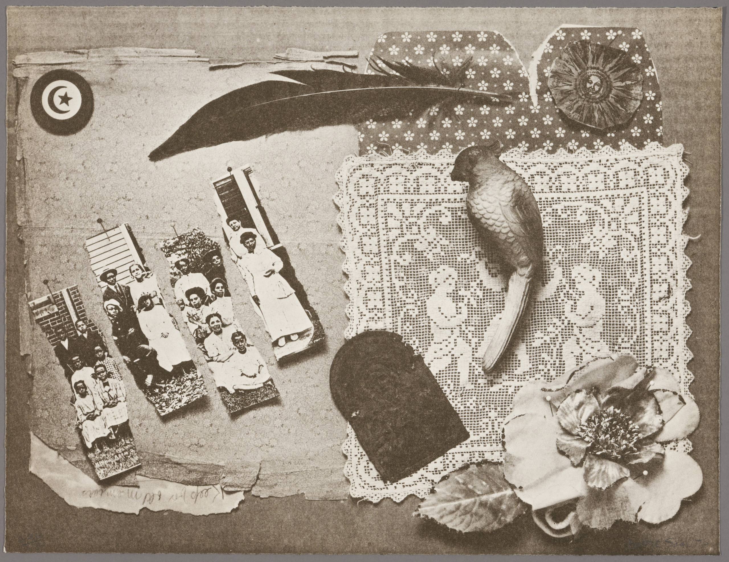 A gray-brown collaged artwork appears to be a collection of seemingly unrelated objects. A lace placemat, a feather, a flower, and an old paper compose much of the work. The left-hand side features a photograph torn to strips, showing a group portrait of dark-skinned people in formal attire.