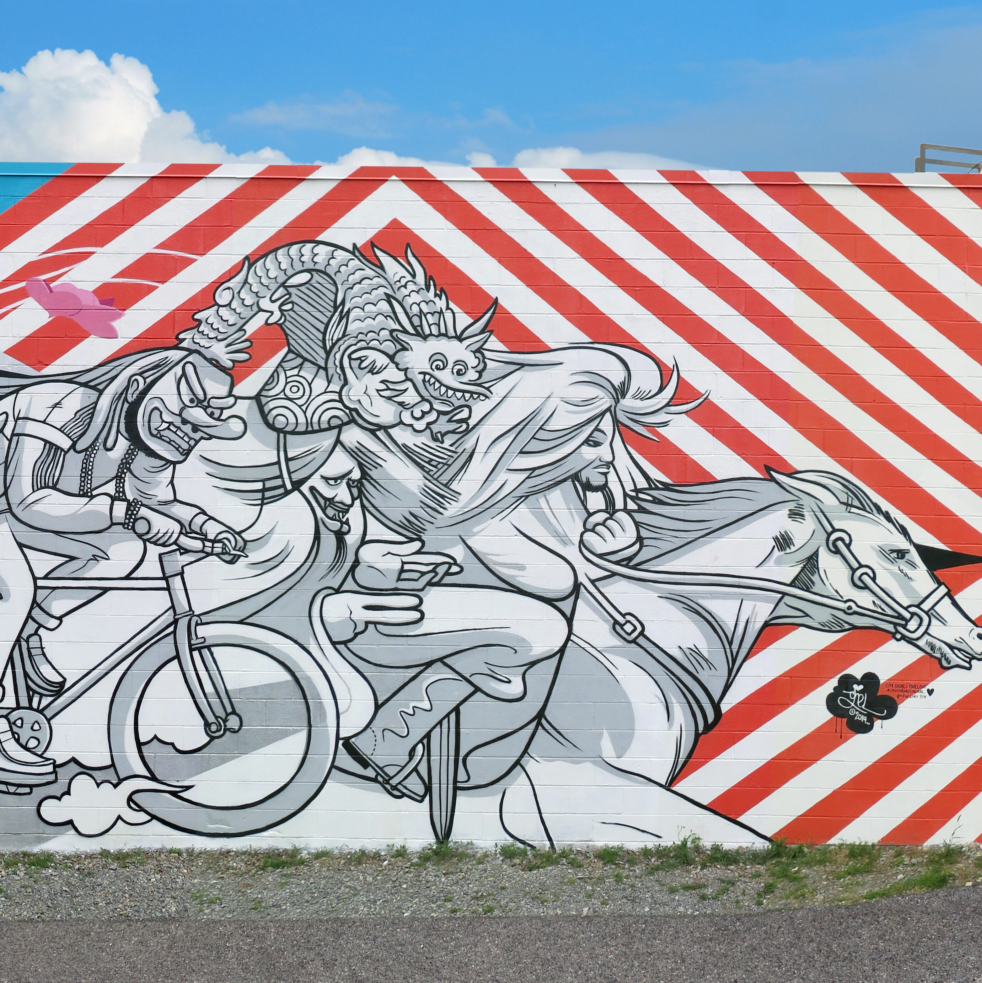 Several black-and-white figures wear masks and ride bicycles, led by a figure on horseback. The background features red and white stripes, blue, and pink flowers.
