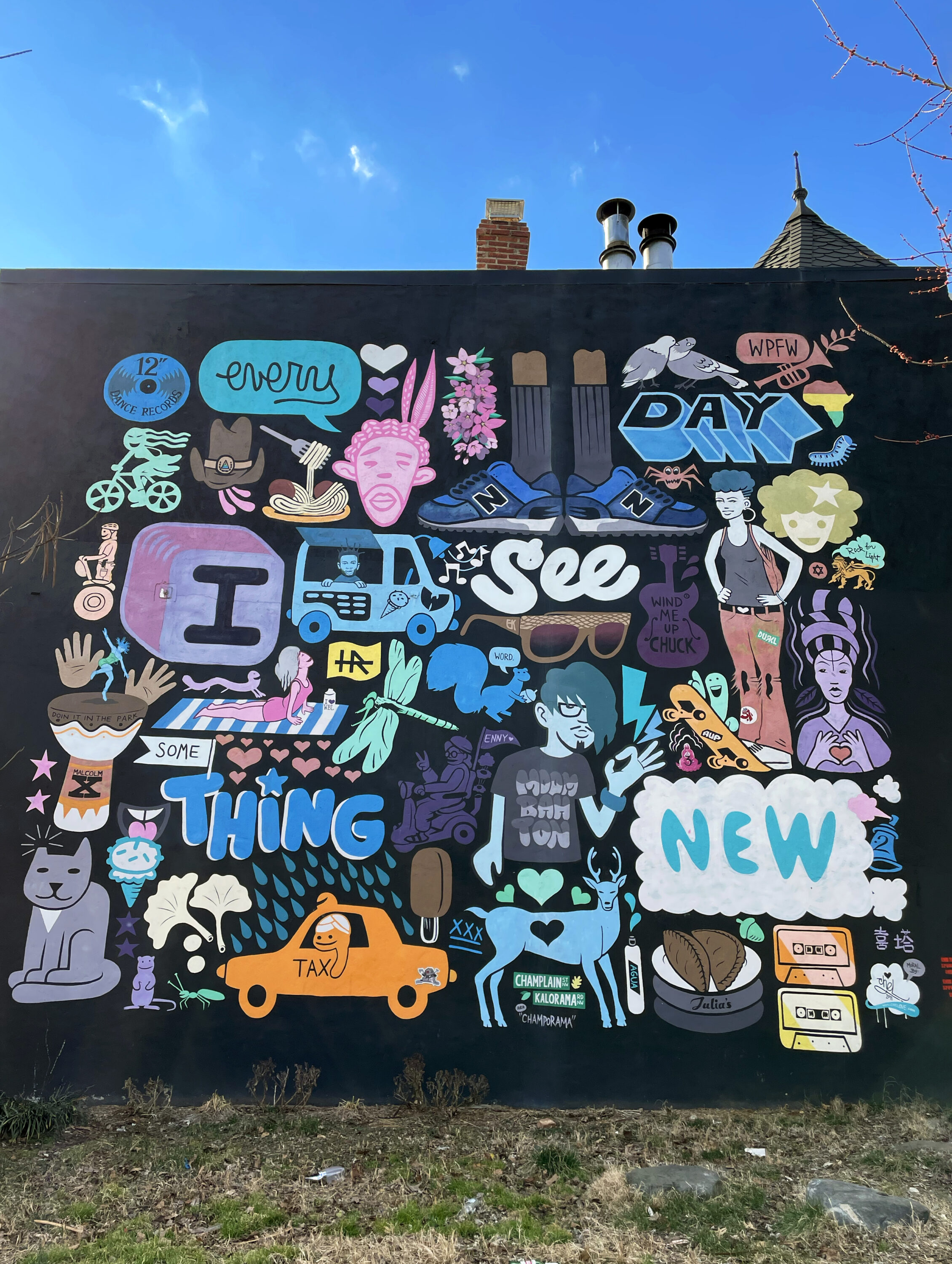 Colorful icons of people, animals, and objects set against a black background. The words “every day I see something new” are painted in brightly colored graphic text spread throughout the mural.