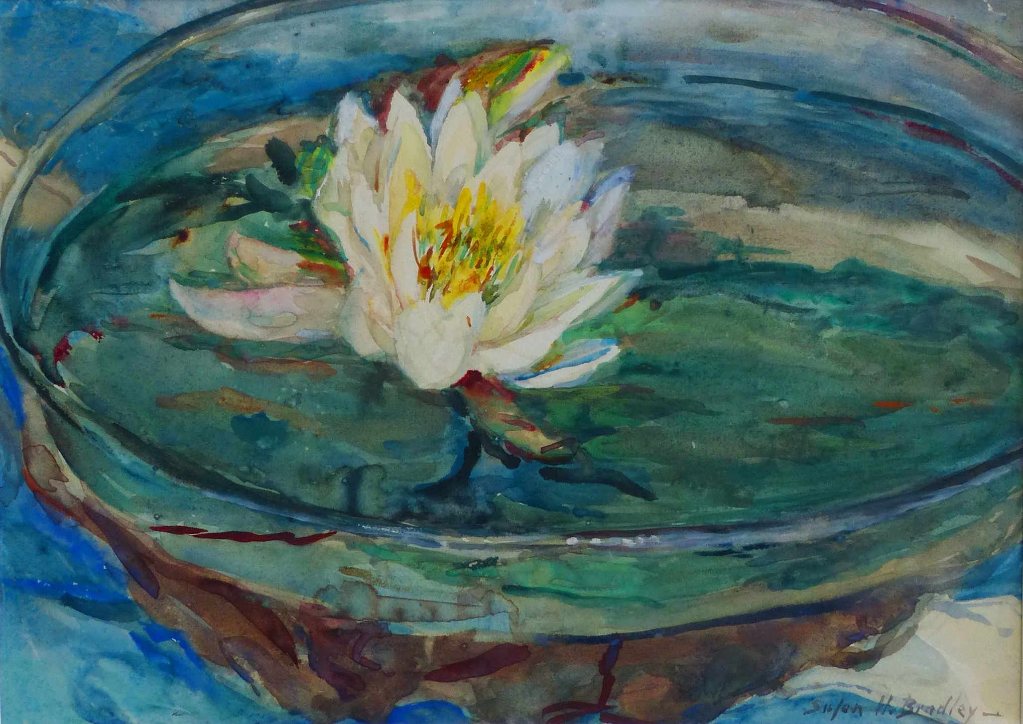 A watercolor painting features a white pond lily with a yellow center floating in what looks to be a clear glass bowl, in blue and green water.