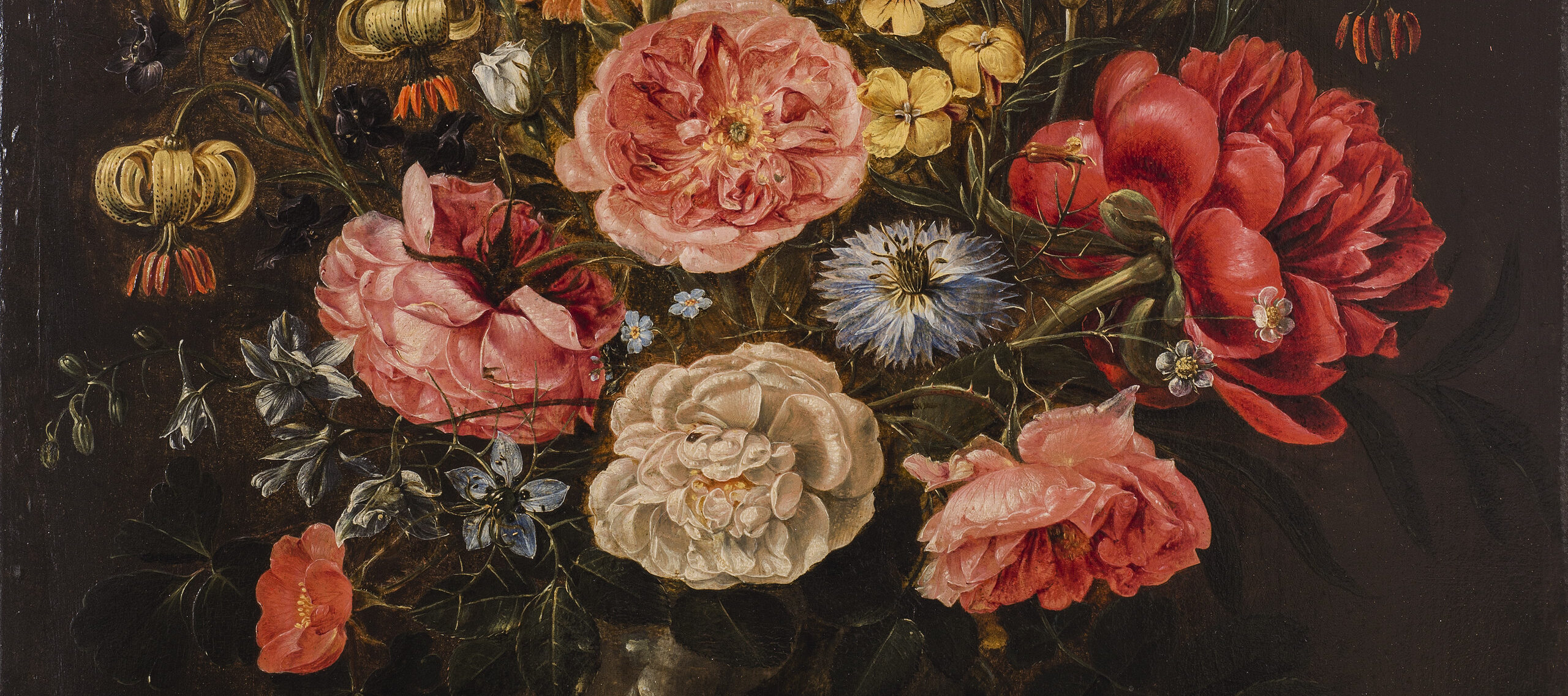 Realistic and detailed, the still life painting meticulously renders a variety of brightly colored flowers densely arranged in a dark round vase set against a dark background. The vase sits upon a stone ledge with two stray pink roses laying in the foreground.