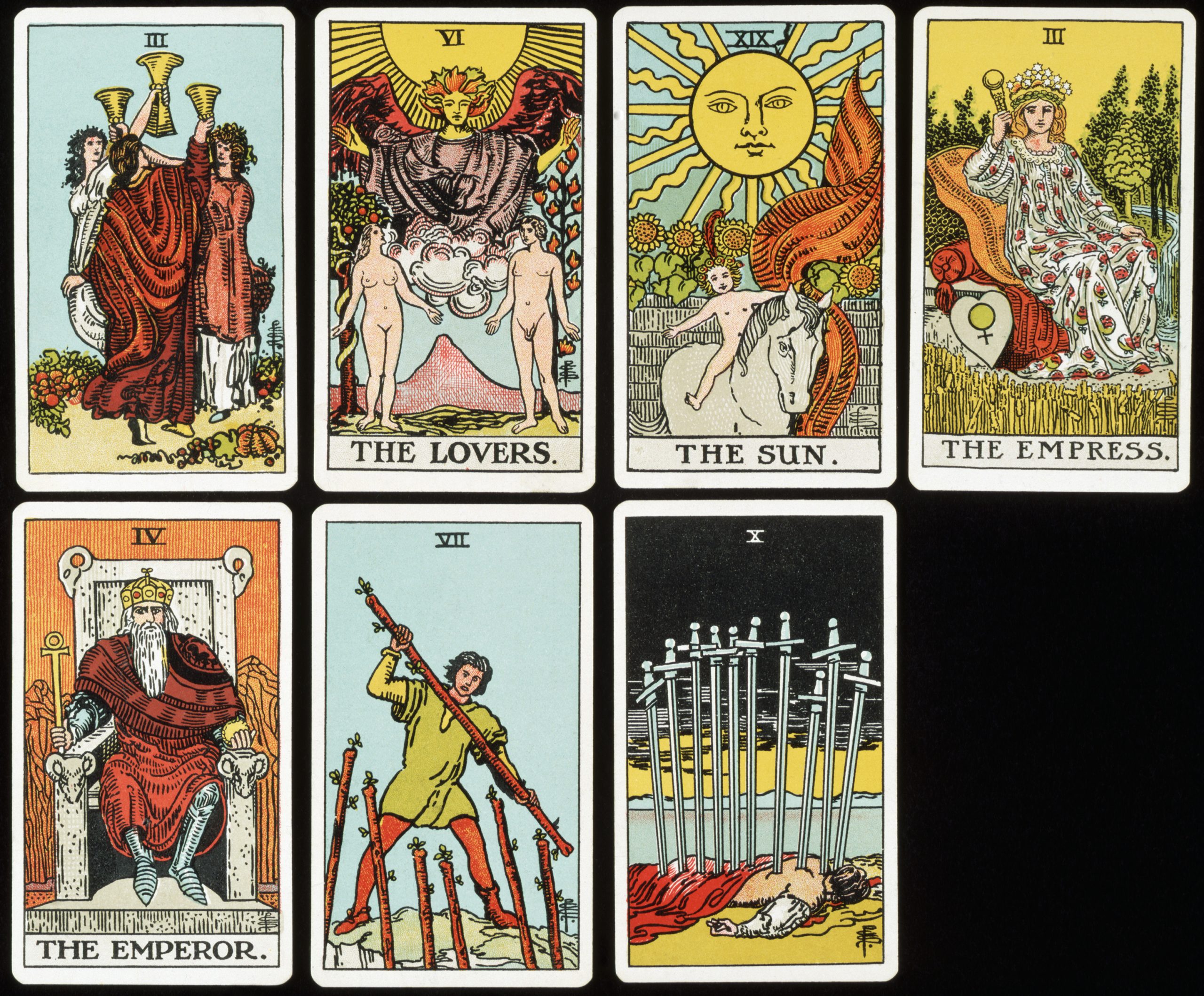 A set of seven Tarot cards rests on a black surface. The cards are illustrated with bright colors and depict mythical scenes. Some cards have text such as “The Sun” or “The Empress” in big bold letters written underneath the illustrations.