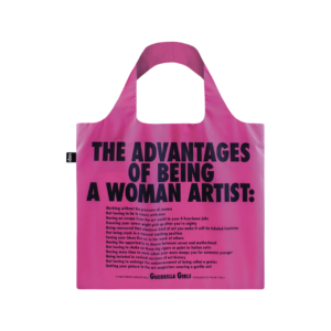 A bright pink tote bag with large, bold black text that says "The Advantages of Being a Woman Artist" with a list of text underneath. 