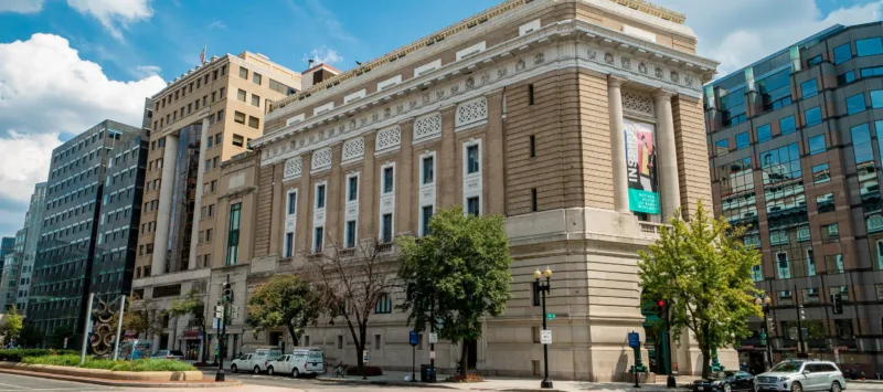 Exterior color photo of the museum building with a blue sky and clouds.