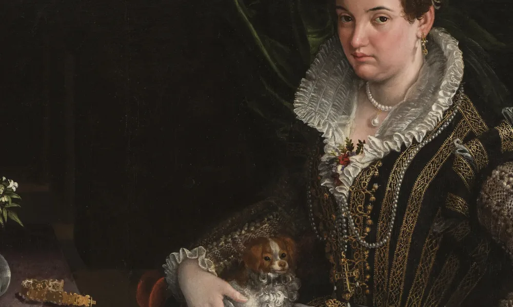 A light-skinned, dark-haired woman wearing pearl and gold jewelry and a black-velvet, lace, and brocade gown poses with her lap dog. Seated in a red velvet chair in the foreground, she makes eye contact with viewers while pressing her hand on the armrest, as if to stand.