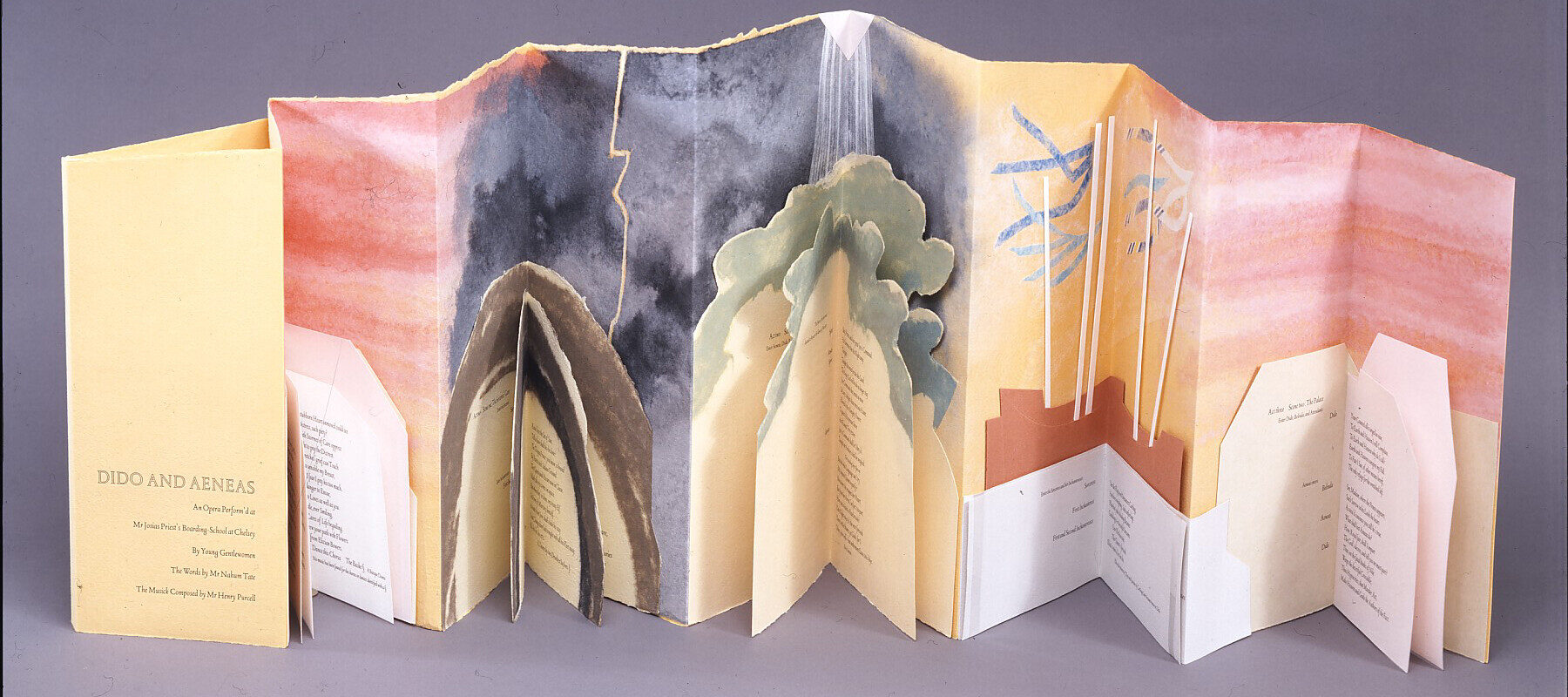 Accordion book of peach paper. Blocks of text, in geometric and organic-shaped boxes, occupy the lower half of the pages. Each block of text has additional folds, forming a mini-book. Above, warm colors fade into dark skies, trees, and ship masts, and then again into pink tones.
