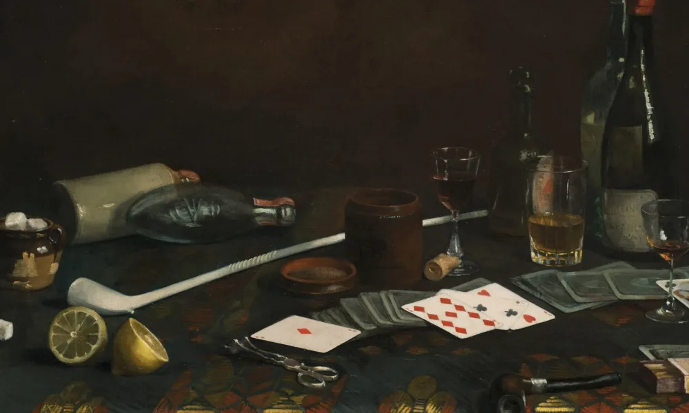 Painting of a blue tablecloth with gold and red pattern. Strewn across the top are half-empty glasses of wine and brown liquid, playing cards, lemon halves and matches. Two pipes, one long and white, one small and dark, lie next to a container of sugar cubes, corks, and bottles.