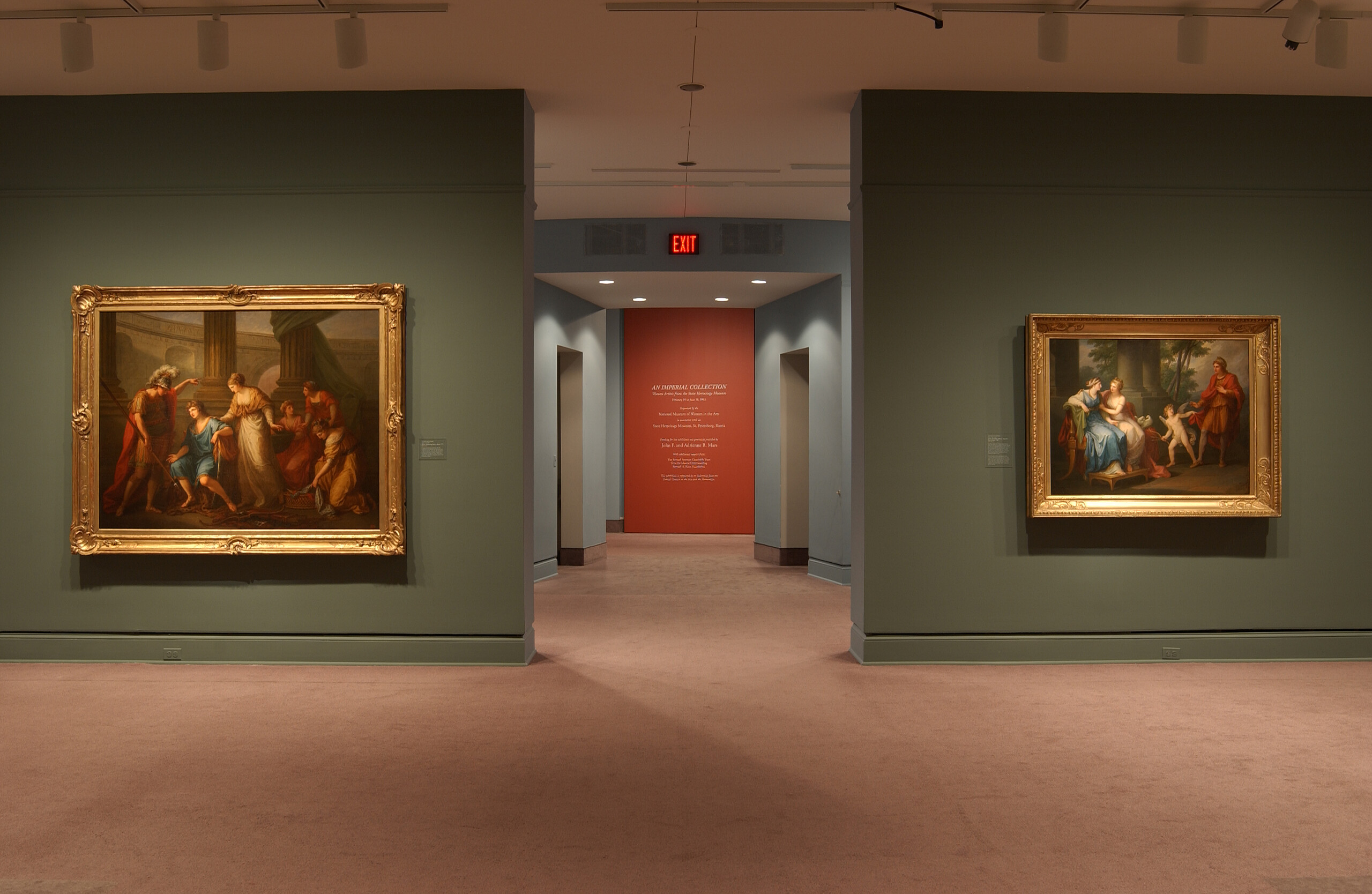 Installation image of an exhibition. Two large oil paintings hang on opposite walls. The walls are painted in sage green. The paintings are framed in golden frames and portray mythical scenes.