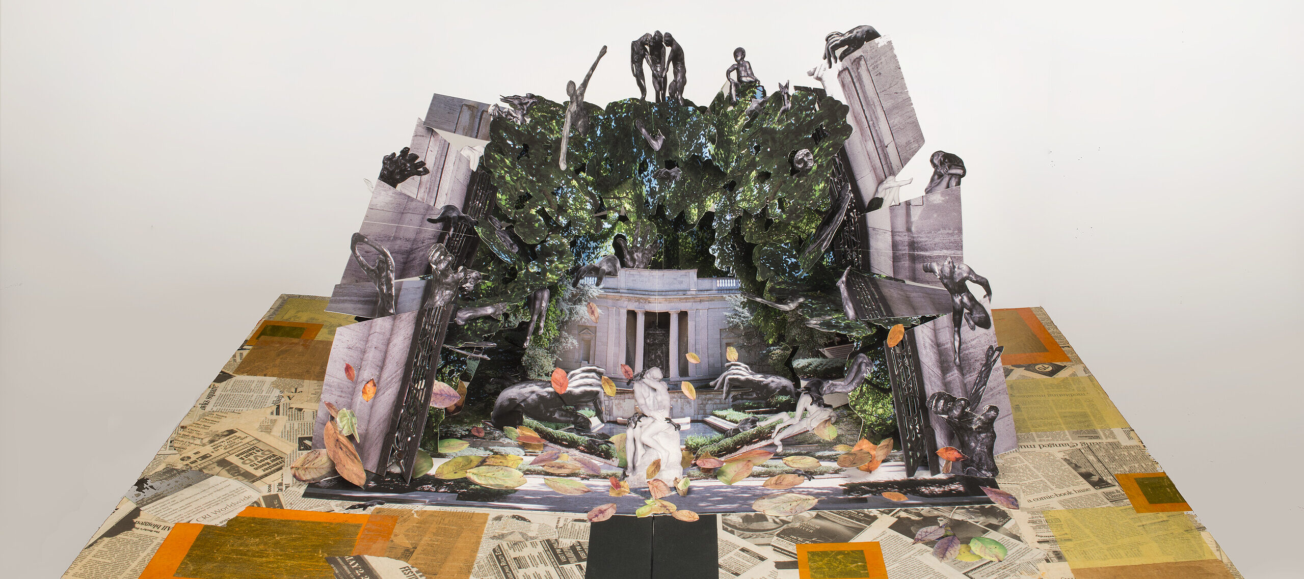 Large-scale pop-up book with Auguste Rodin's and Camille Claudel's sculptures in a deconstructed classical building. Sculptures populate a mass of greenery that overtakes the building, bordered by crumbling columns. Scattered petals of color match the collaged newspaper base.