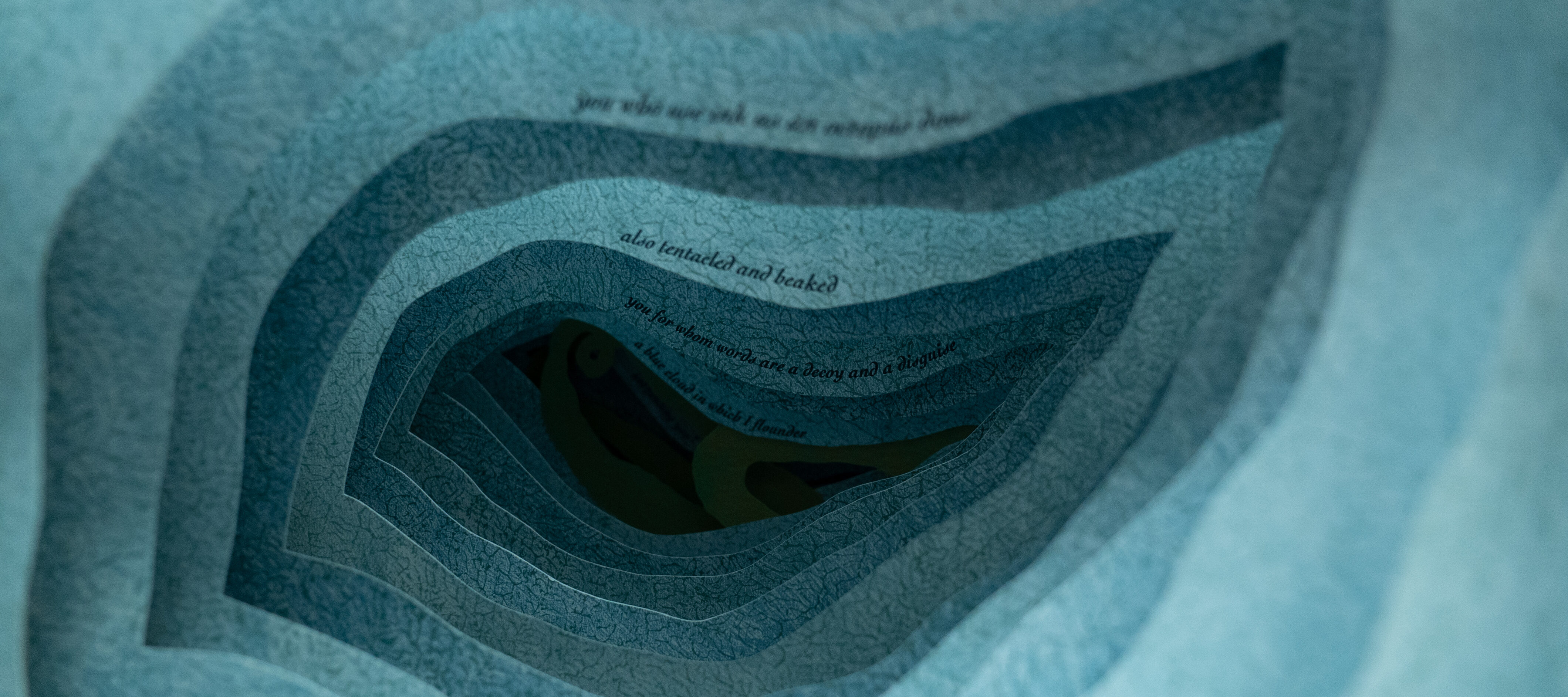 A close up photograph of an artist's book. Each layer of blue paper has an organic, irregular shape cut out of the middle so the layers form a tunnel. A line of text is printed in small type on each page, receding into the tunnel like an underwater cavern.
