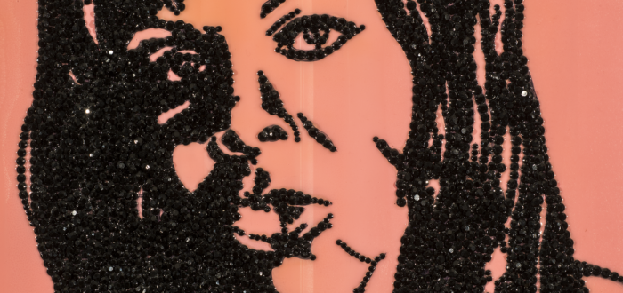 An enamel portrait painting of a woman made with encrusted black rhinestones glued to shiny pink acrylic background.