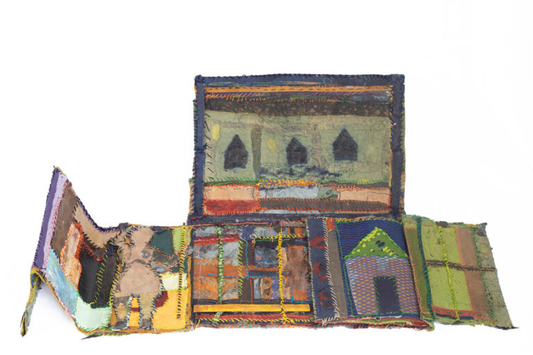 A artist's book made of colorful handmade paper stitched with yellow, orange, blue, green, and black thread.