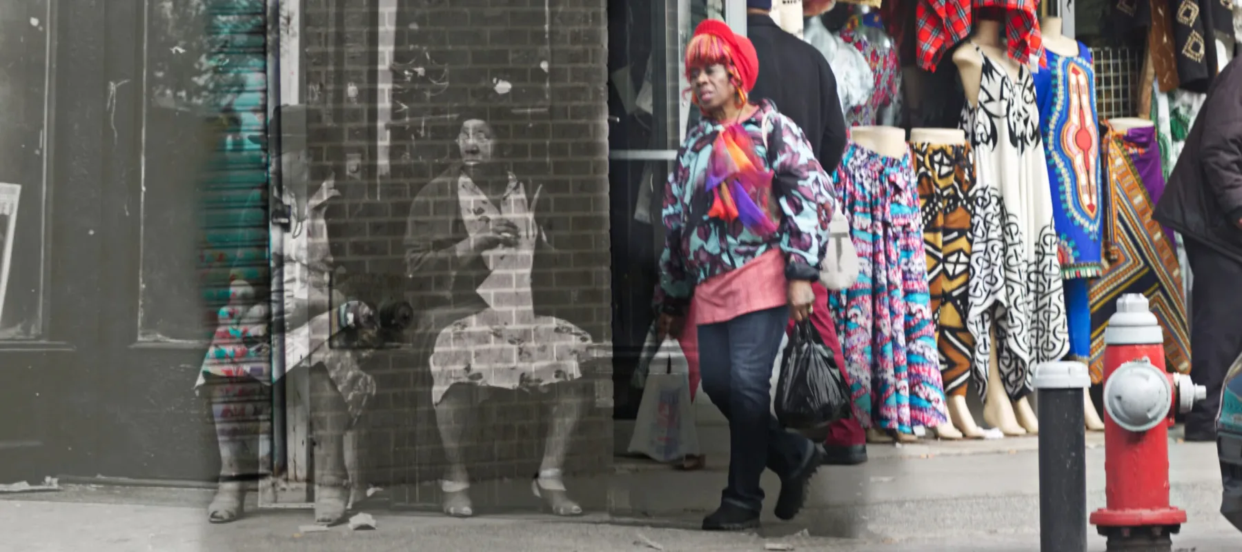 A medium-dark skinned adult woman in a colorful top standing next to a street-front clothing store, overlaid on a black-and-white image of two medium-dark skinned adult women sitting in front of an urban brick building.