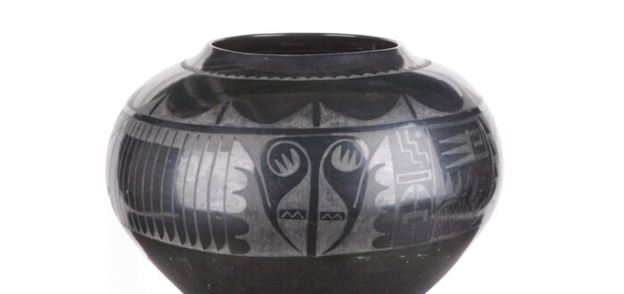 Blackware jar made of clay and volcanic ash. A painted, matte design adorns the upper half of the jar.