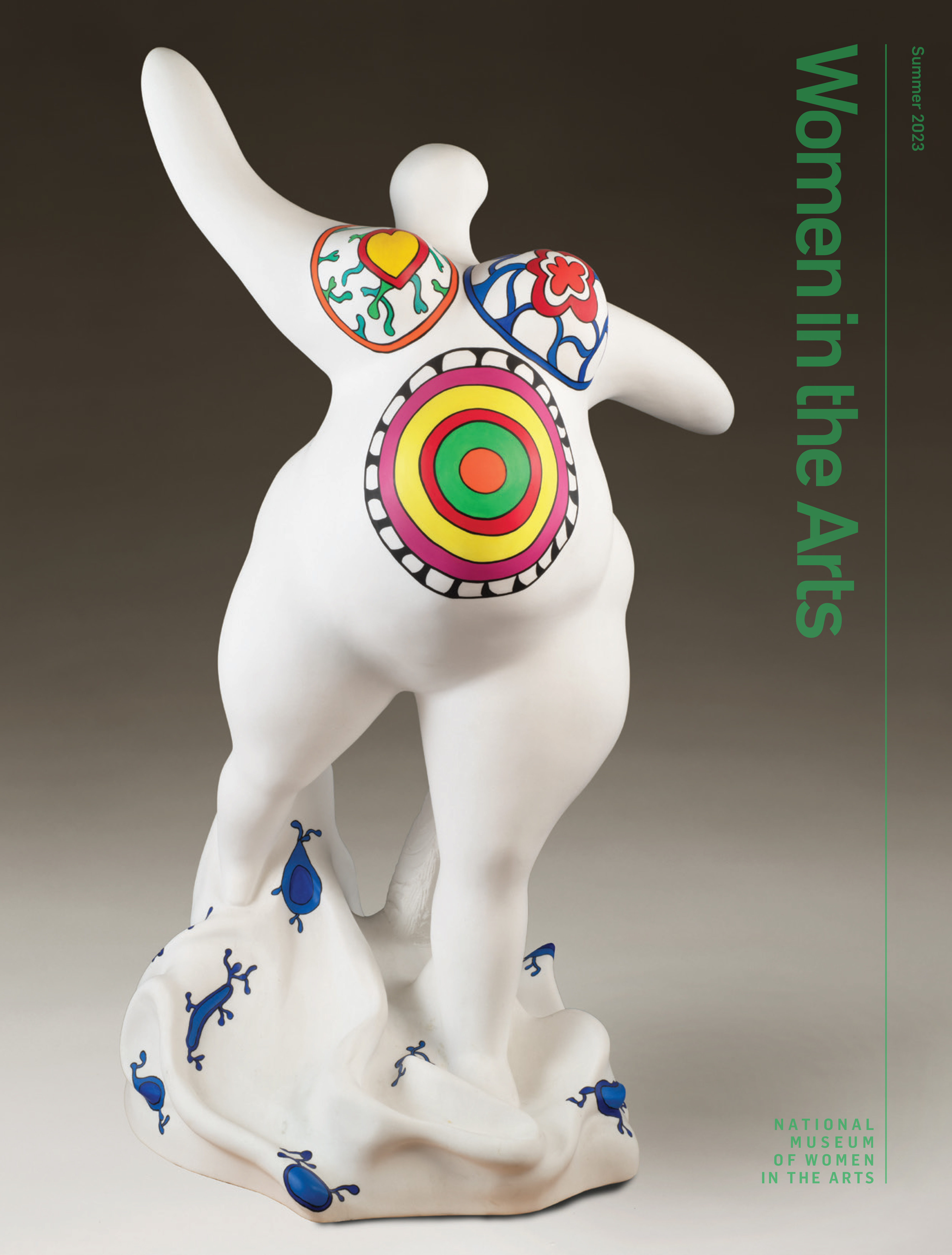 A magazine cover with an image of a marble Niki de Saint Phalle sculpture depicting an abstracted, voluptuous figure with a pregnant belly. The figure is covered in bright patterns and posed stepping forward, with raised, outstretched arms.