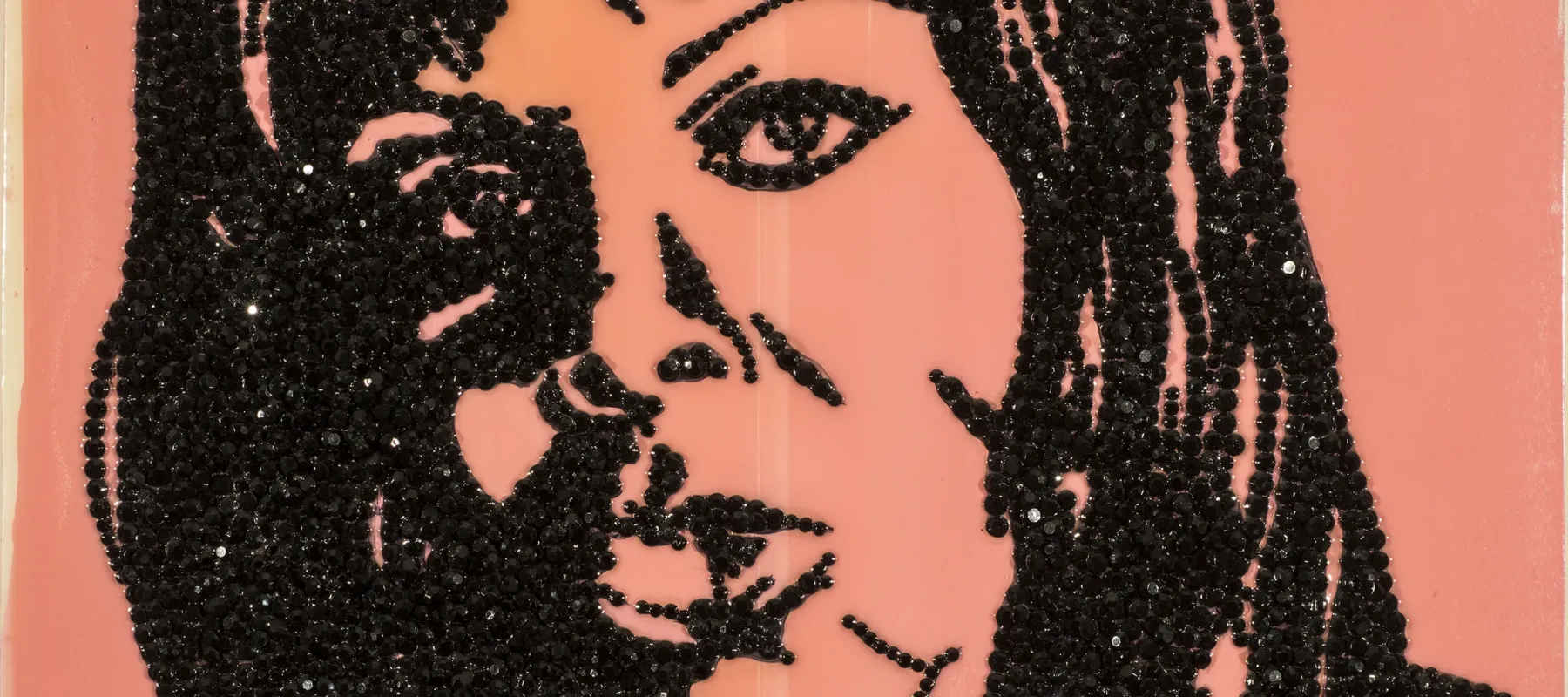 An enamel portrait painting of a woman made with encrusted black rhinestones glued to shiny pink acrylic background.