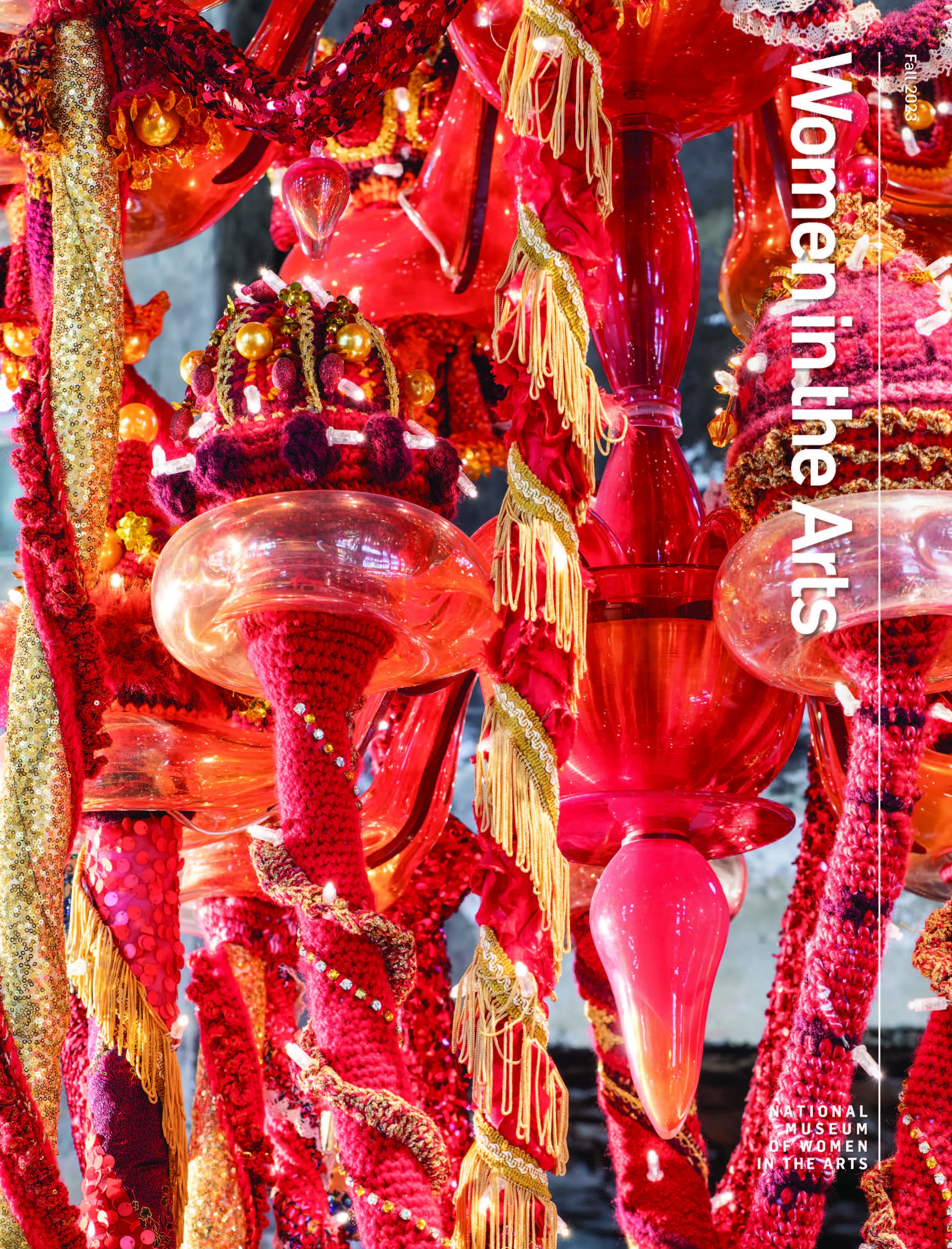 The cover of the Fall 2023 "Women in the Arts" magazine with a detail photograph of a hanging glass sculpture wrapped in brilliant red and gold thread.