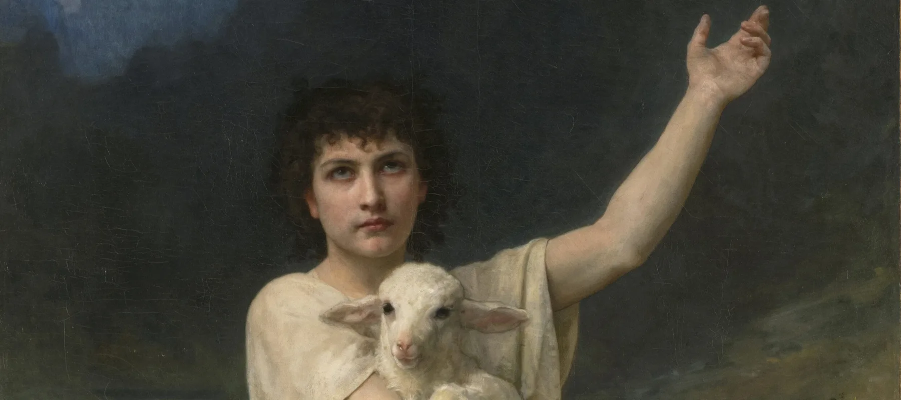 Realistic painting depicts a light-skinned young man with dark curly hair, wearing a white tunic, set before distant mountains. He is kneeling victoriously atop a fearsome dead lion, clutching a serene lamb his right arm and gesturing heavenward with his left arm.