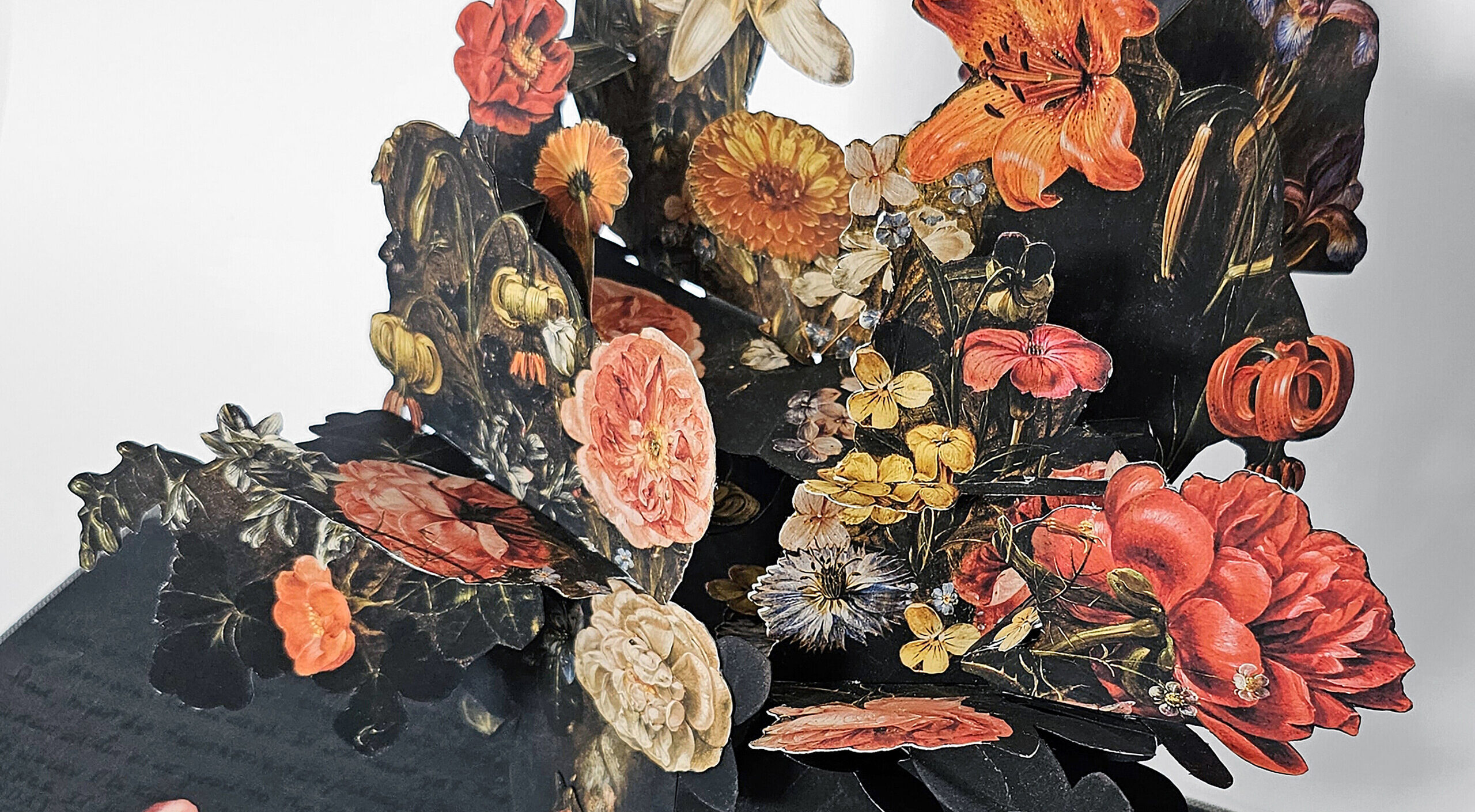 An artist's book, opened to reveal a pop-up of many colorful flowers in a vase. The pages are dark with black writing.