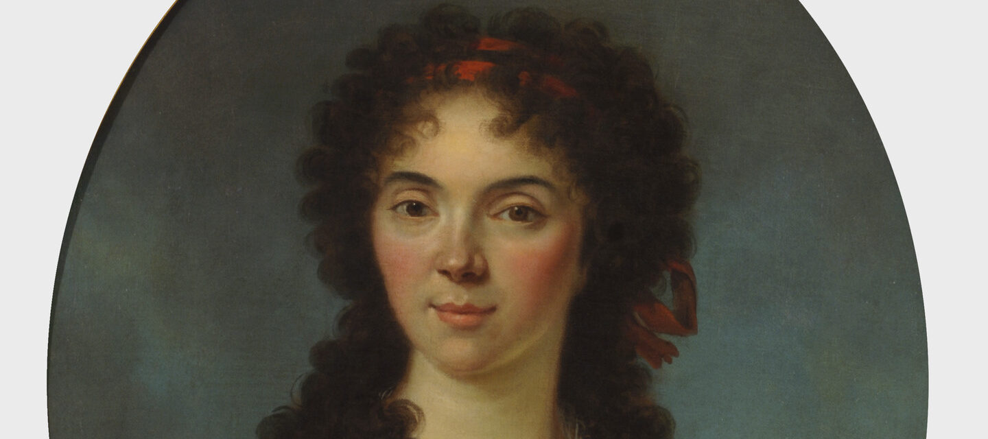 Oval portrait of a young woman with light skin gazes out at the viewer with her dark tousled curls framing her face and shoulders.