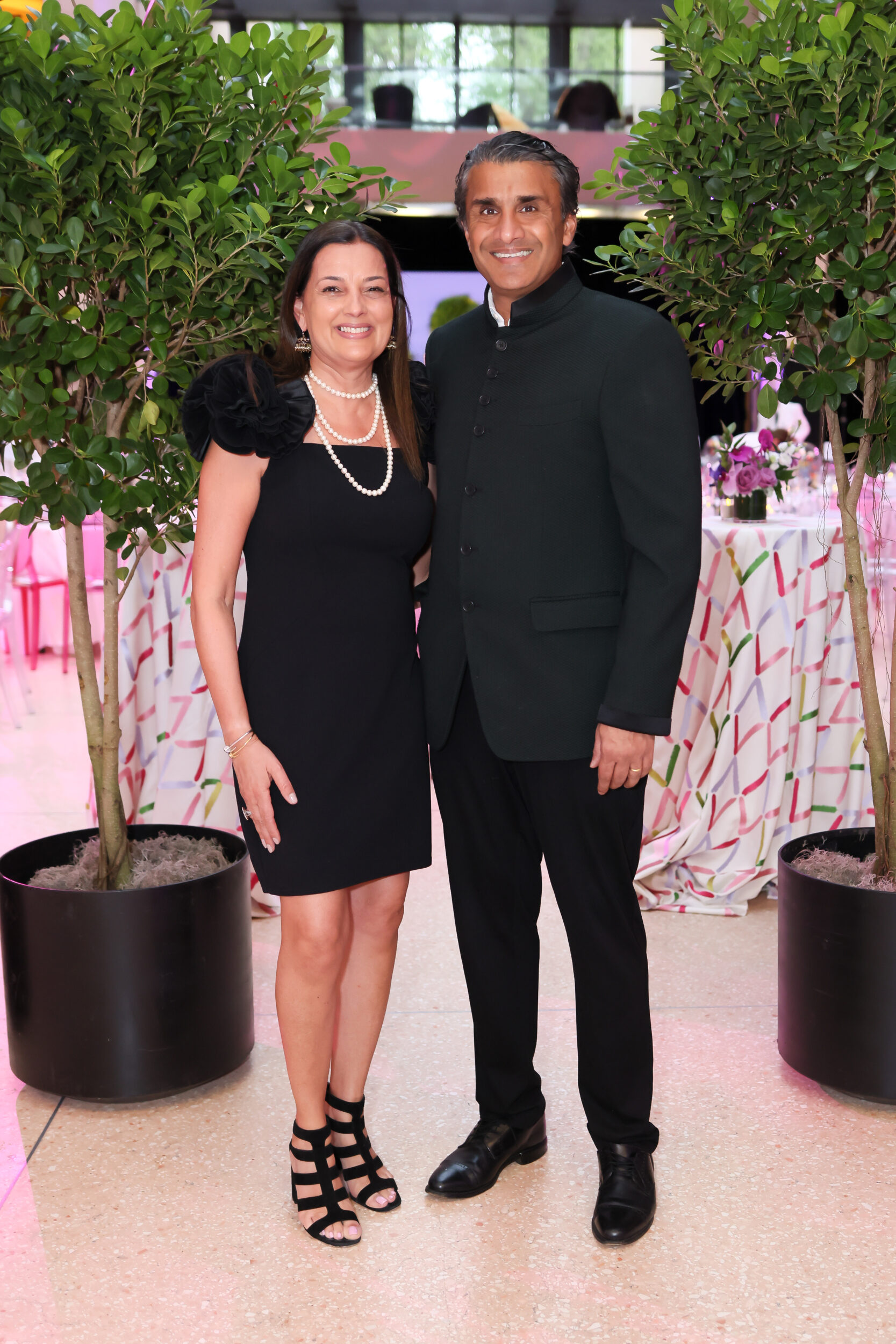 A light-skinned woman and a medium-skinned man pose for a photo at a black-tie event.
