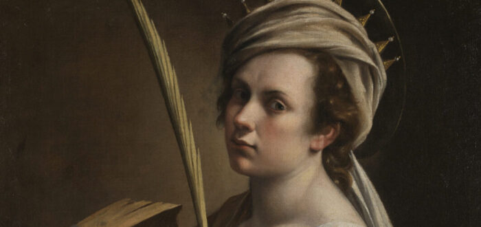 Against a dark black and brown background, a light skinned woman in a red dress with wavy reddish-brown hair wears a white cloth and gold crown around her head. Her right hand clutches a palm while her left grazes a spiked breaking wheel. She stares straight at the viewer.