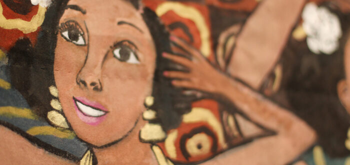 Close-up photograph of a painted quilt shows a medium-dark skinned woman dancing exuberantly. There is a white flower in her hair, and she wears dangling gold earrings and gold loops around her neck.