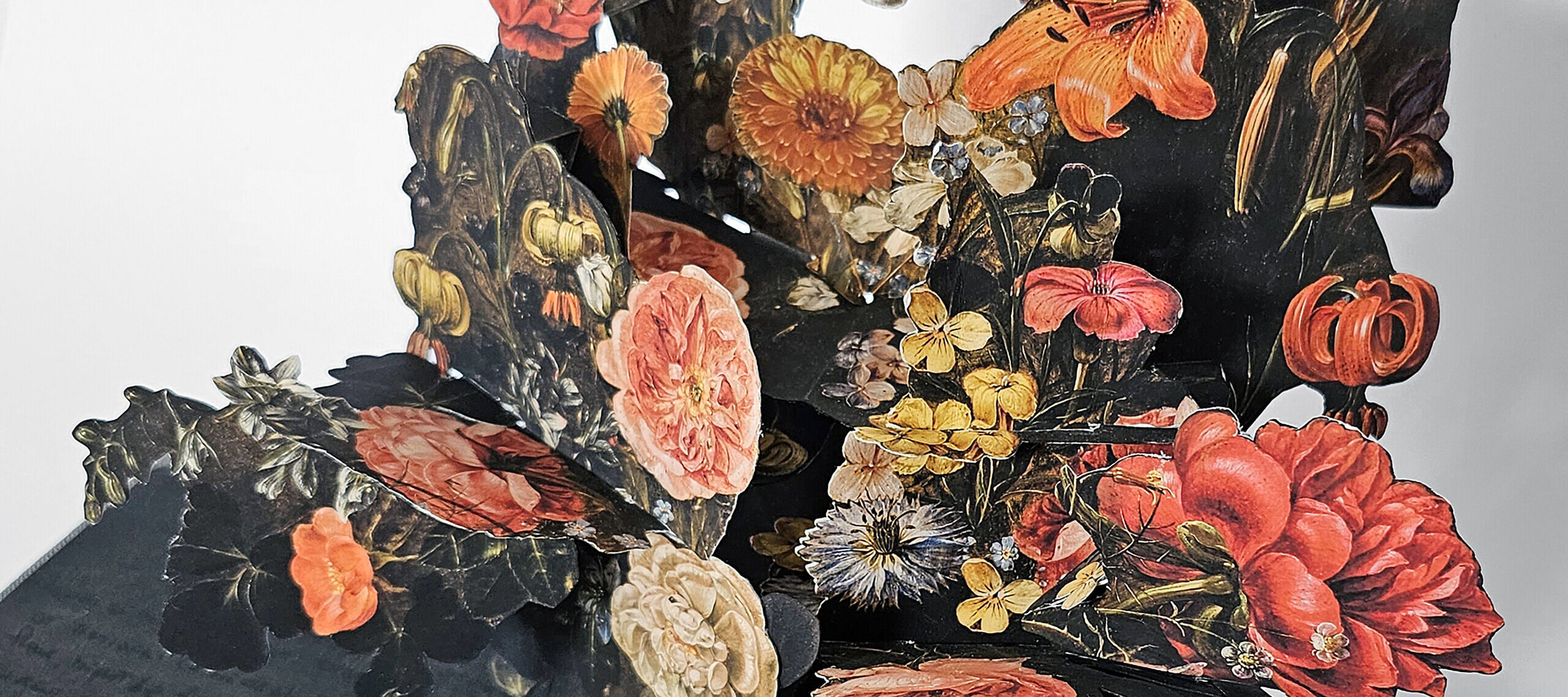 An artist's book, opened to reveal a pop-up of many colorful flowers in a vase. The pages are dark with black writing.
