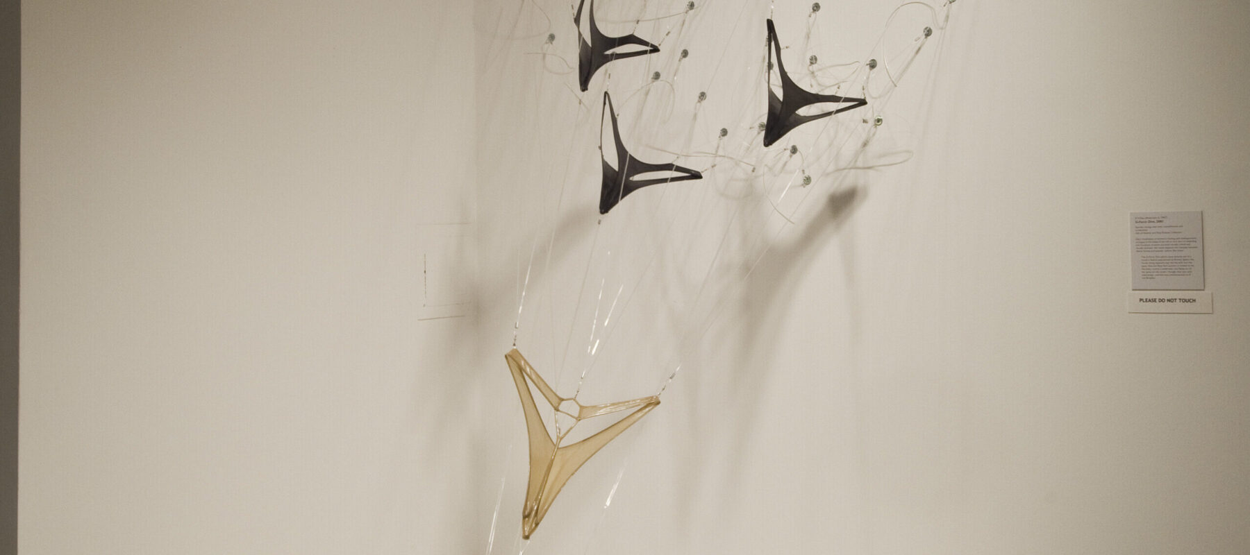 A sculpture made made from spandex and objects resembling military planes flying down towards the ground.