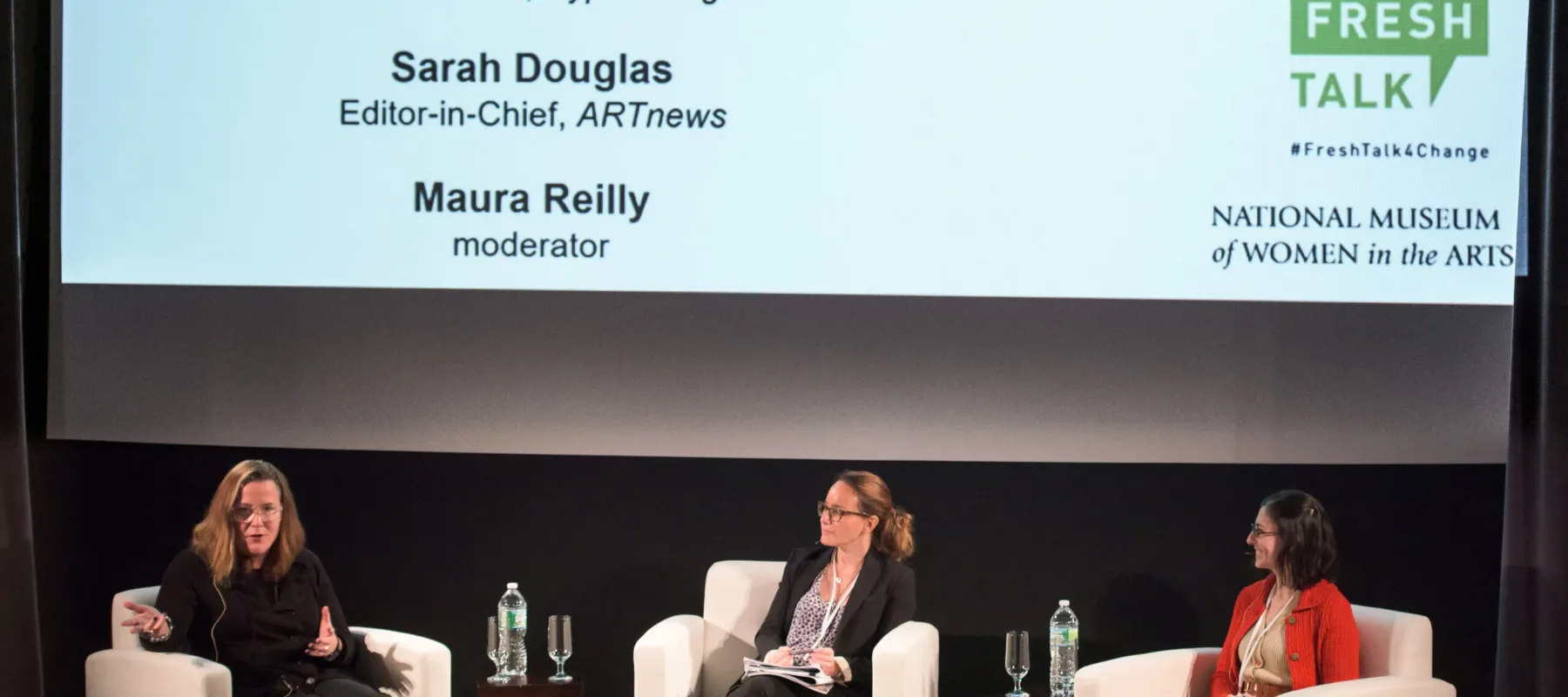 Three women are sitting on a stage giving a talk. In large letters, the title above them says "Fresh Talk."