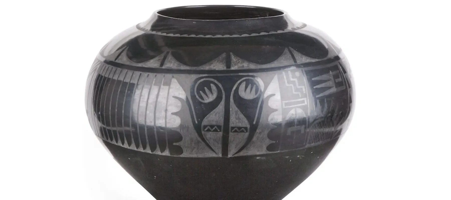 Blackware jar made of clay and volcanic ash. A painted, matte design adorns the upper half of the jar.