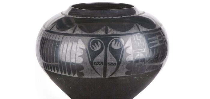 Blackware jar made of clay and volcanic ash. A painted, matte design adorns the upper half of the jar.