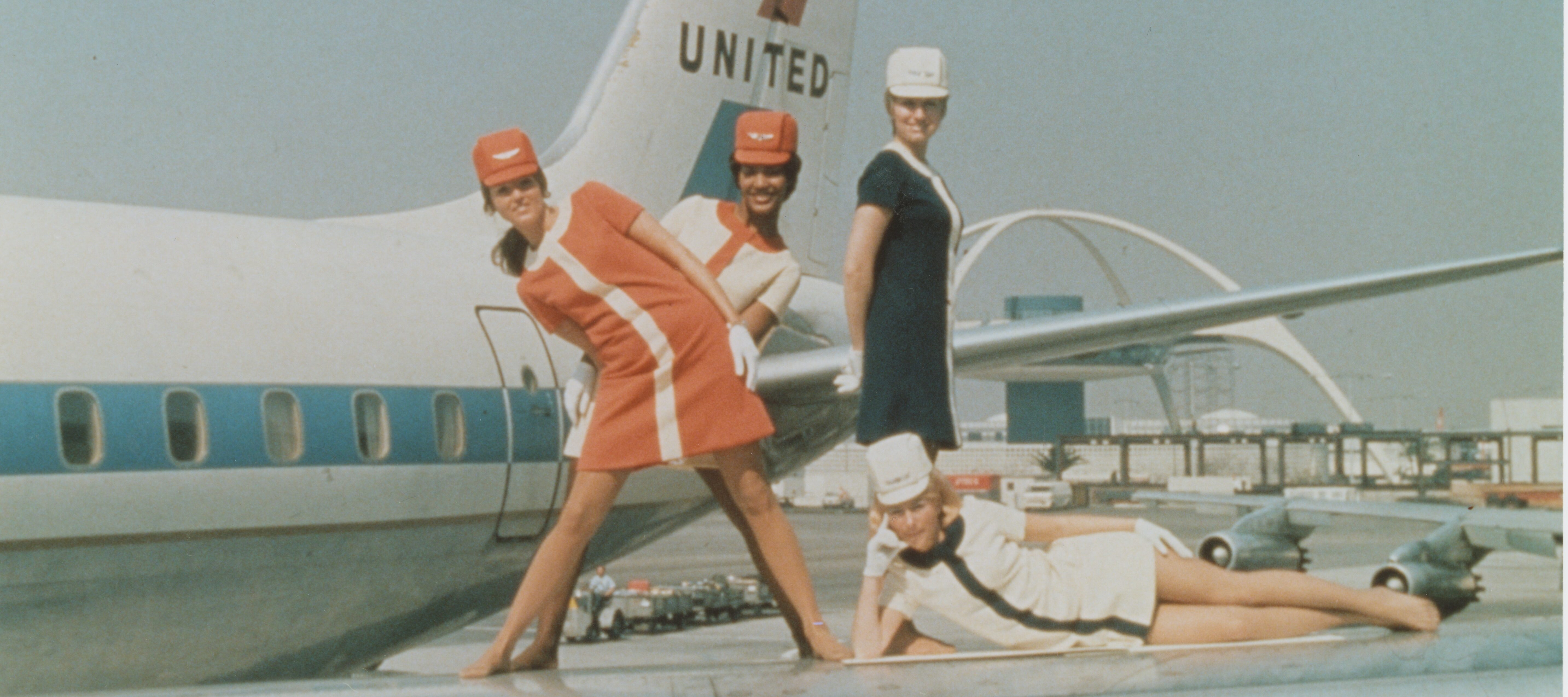 Four women flight attendants pose on the wings of a United Airlines plane in the 1960s.