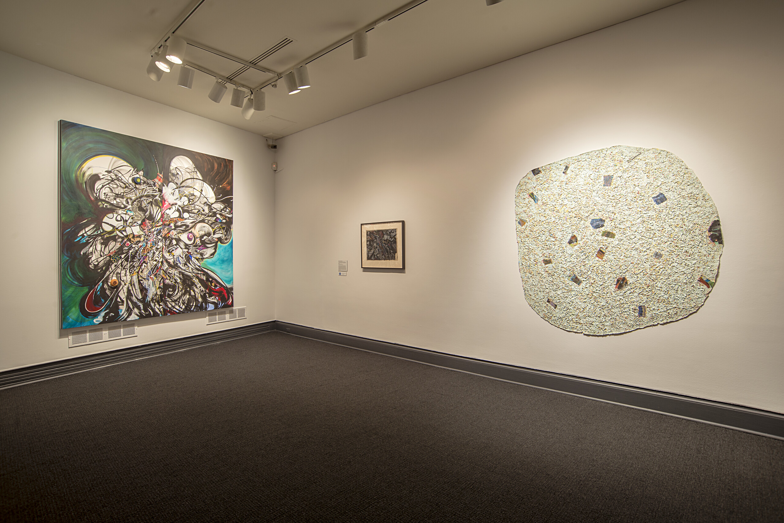 An installation view of several abstract artworks hung on a gallery wall.