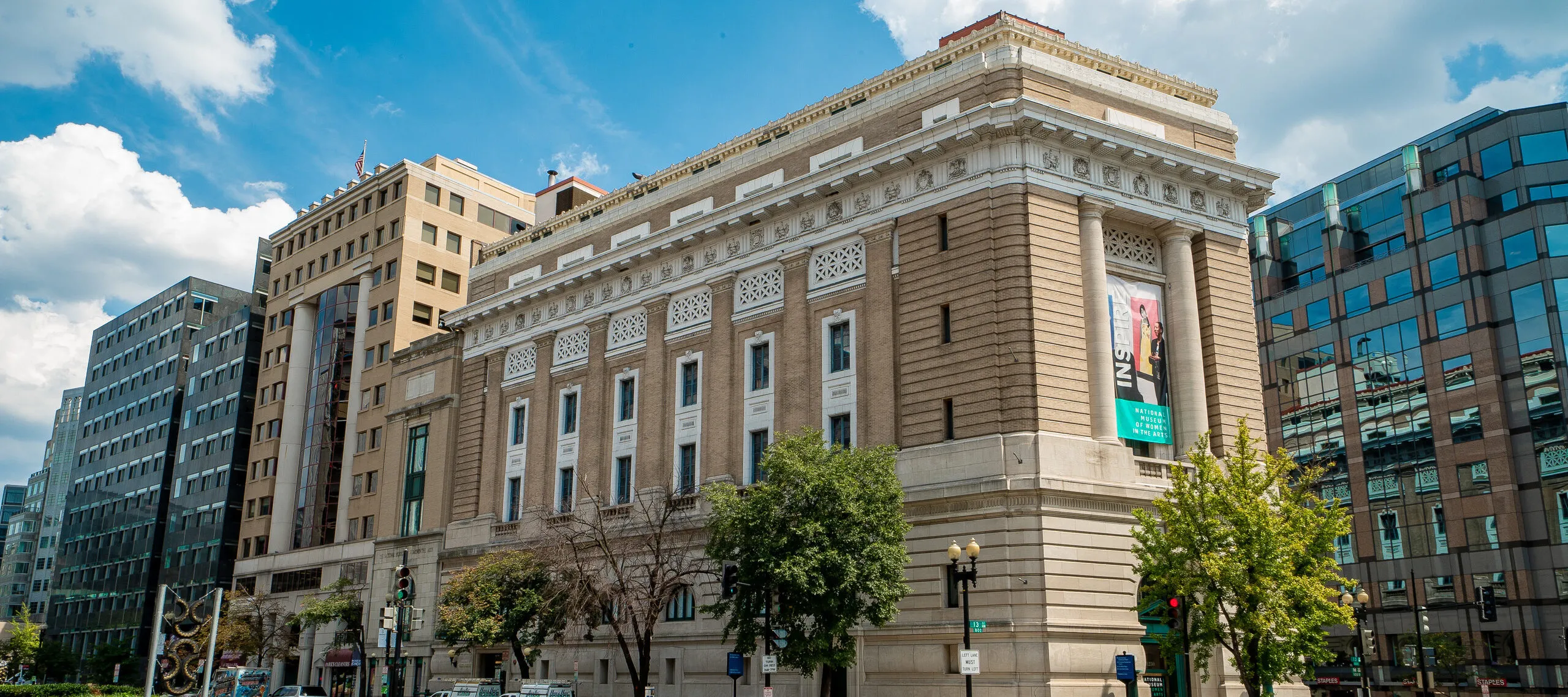 Exterior color photo of the museum building with a blue sky and clouds.